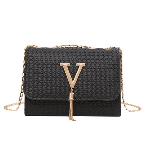 Black woven crossbody bag with gold V metal fringe and chain strap on white background