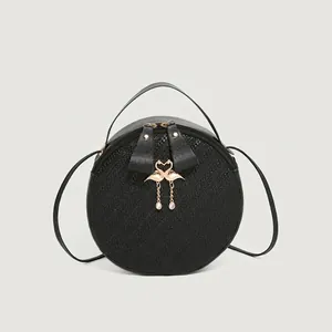 Classic black round shoulder bag with woven texture and golden flamingo metal charms