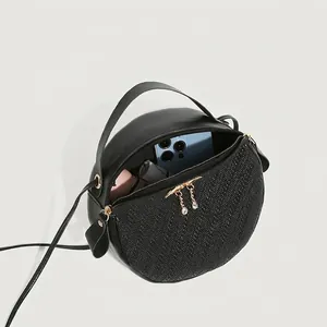 Classic black round crossbody bag with woven texture and dual zipper closure details