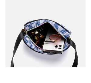 Interior view of denim shoulder bag holding a smartphone, sunglasses and cosmetics