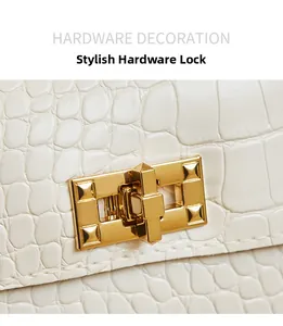 Detail of white crocodile-embossed leather handbag featuring a golden hardware twist lock