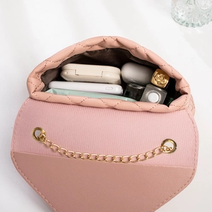 Pink quilted crossbody bag with gold chain showing internal capacity for daily items