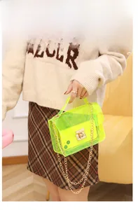 Detail of neon green transparent PVC bag with gold chain strap and metal turn-lock