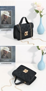 Detail of black quilted crossbody bag featuring a golden lock and luxury chain strap