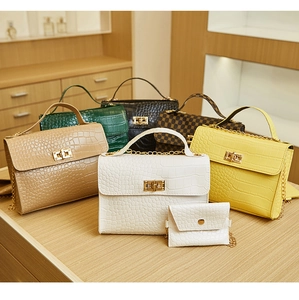 Macro detail of crocodile pattern leather handbags with gold clasps and chain straps