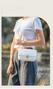 Detailed view of white quilted chain crossbody bag with golden oval twist lock closure