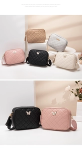 Close-up of quilted crossbody bag with butterfly metal charm and leather tassel detail