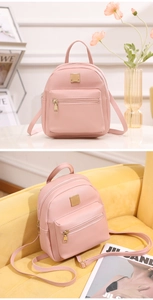 Dettaglio mini zaino rosa in pelle PU con finiture dorate su una scrivania elegante