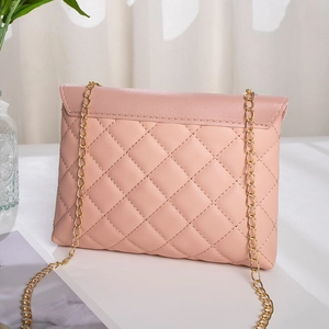 Elegant pink quilted crossbody handbag for women with gold chain strap in soft lighting