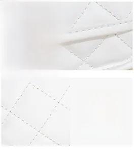 Detailed macro view of white quilted leather texture with precise stitching and fabric gloss