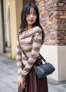 Side view of a vintage Boston bag with grey check pattern worn by a model in the street