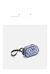 Detail of blue checkerboard denim shoulder bag with leather trim and gold zipper