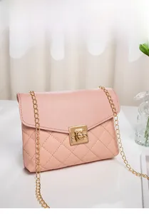 Detail of pink quilted crossbody bag featuring a golden square lock and fine chain strap