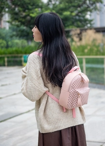 Close-up of pink mini backpack featuring geometric textures and adjustable straps