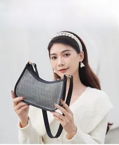 Detail of checkered rhinestone crescent bag with leather trim and gold metal buckle