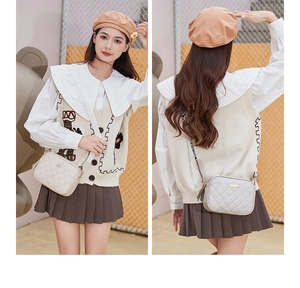 Close-up of beige quilted crossbody bag with gold butterfly clasp and leather tassel detail