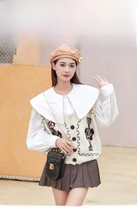 Mannequin en extérieur portant un petit sac bandoulière noir imprimé à chaîne dorée