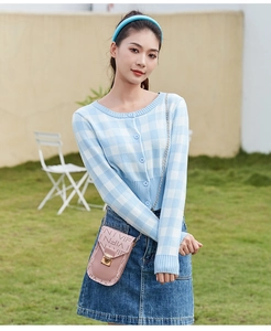 Photo en plein air d'un sac bandoulière rose avec motif VIFN et fermoir doré sur mannequin