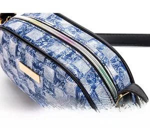 Close-up of blue and white checkered fabric with a colorful zipper and gold nameplate