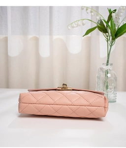 Detail of pink quilted square bag featuring gold twist-lock and elegant metal hardware