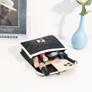Quilted black crossbody bag with white trim and gold lock showing interior daily capacity