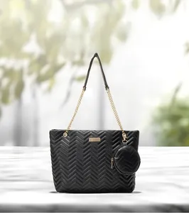 Detail of black V-quilted tote bag with gold chain strap and detachable round coin purse