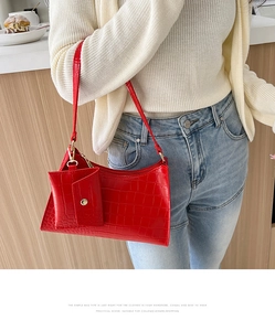 Red crocodile pattern shoulder bag with matching mini pouch accessory on model