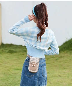Vue en extérieur d'un mini sac à bandoulière beige avec bandoulière en chaîne