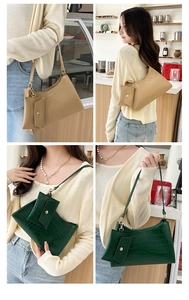 Detail view of crocodile pattern hobo bag with mini pouch in apricot and green
