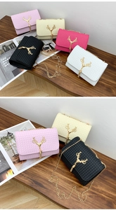 Detail of woven texture bags with gold reindeer charms and tassels on a wooden table