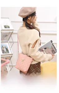 Detail view of pink quilted crossbody bag with a golden turn-lock and leather texture
