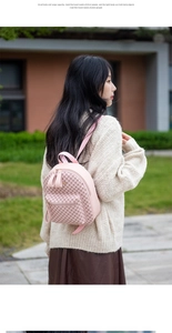 Pink PU leather mini backpack with vintage pattern detail on woman in beige knitwear
