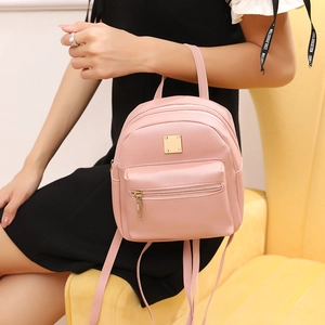 Mini zaino rosa da donna in finta pelle con dettagli dorati tenuto in mano