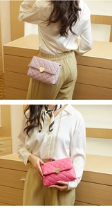Close-up of quilted pattern and heart-shaped metal lock on the chain shoulder bag