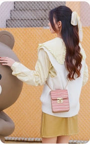 Detailed view of pink crocodile pattern phone bag with golden lock and chain strap