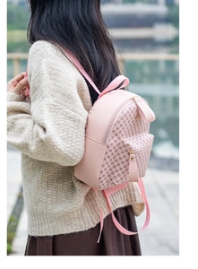 Detail of pink small backpack with rhombic patterns on model in natural light