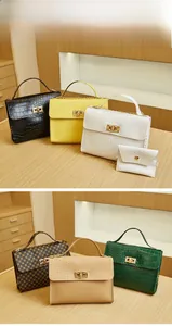 Detail showing various colors of crocodile pattern handbags with gold metal twist locks