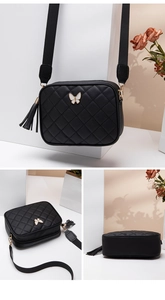 Detail of black quilted camera bag with butterfly metal hardware and fringe tassel