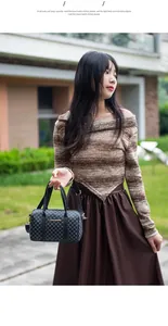 Outdoor shot of a vintage cylinder Boston handbag with grey geometric lattice pattern