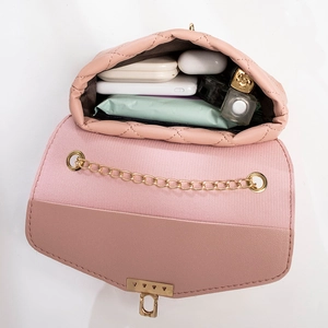 Pink quilted shoulder bag with gold chain strap showing internal storage and daily essentials