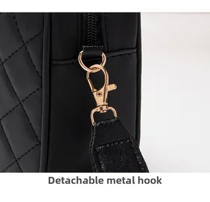 Close-up of detachable light gold metal hook on black quilted leather handbag