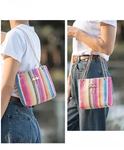 Close-up of rainbow crochet knit shoulder bag with metal chain and flamingo charm