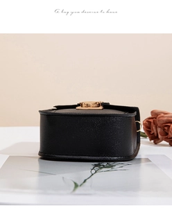 Détail du sac à main en cuir grainé noir avec son fermoir pivotant doré élégant