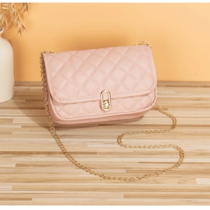 Detail of pink quilted handbag showing gold chain strap and elegant twist lock closure