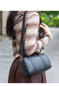 Close-up of a mini Boston bag with geometric prints and luxury gold hardware
