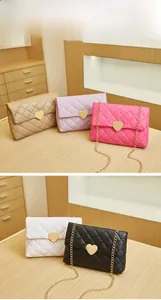 Close-up of quilted heart handbags with golden chain straps and metallic heart closures
