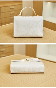 Detailed bottom and side view of white crocodile pattern crossbody bag with chain