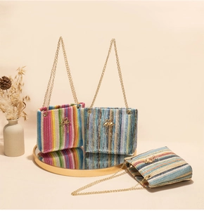Detail of colorful woven straw bucket bags with gold flamingo hardware and chain straps