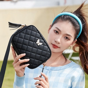 Elegant black quilted shoulder bag with white butterfly clasp and tassel charm detail