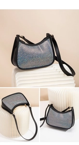 Detail view of crescent shoulder bag featuring iridescent rhinestones and gold zipper